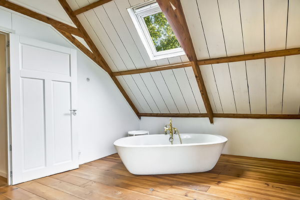 een prachtig bad in een rustieke ruimte met mooie houten balken