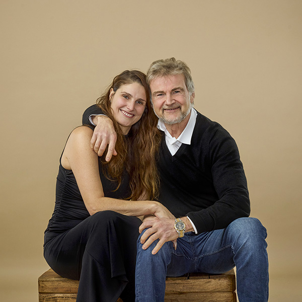een warme gezinsfoto van een vader en dochter die elkaar stevig vasthouden in een zacht verlichte studio in haarlem